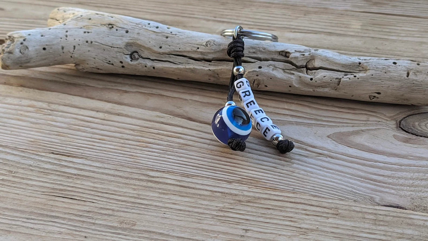Keychain with 'Greece' text on a wooden surface
