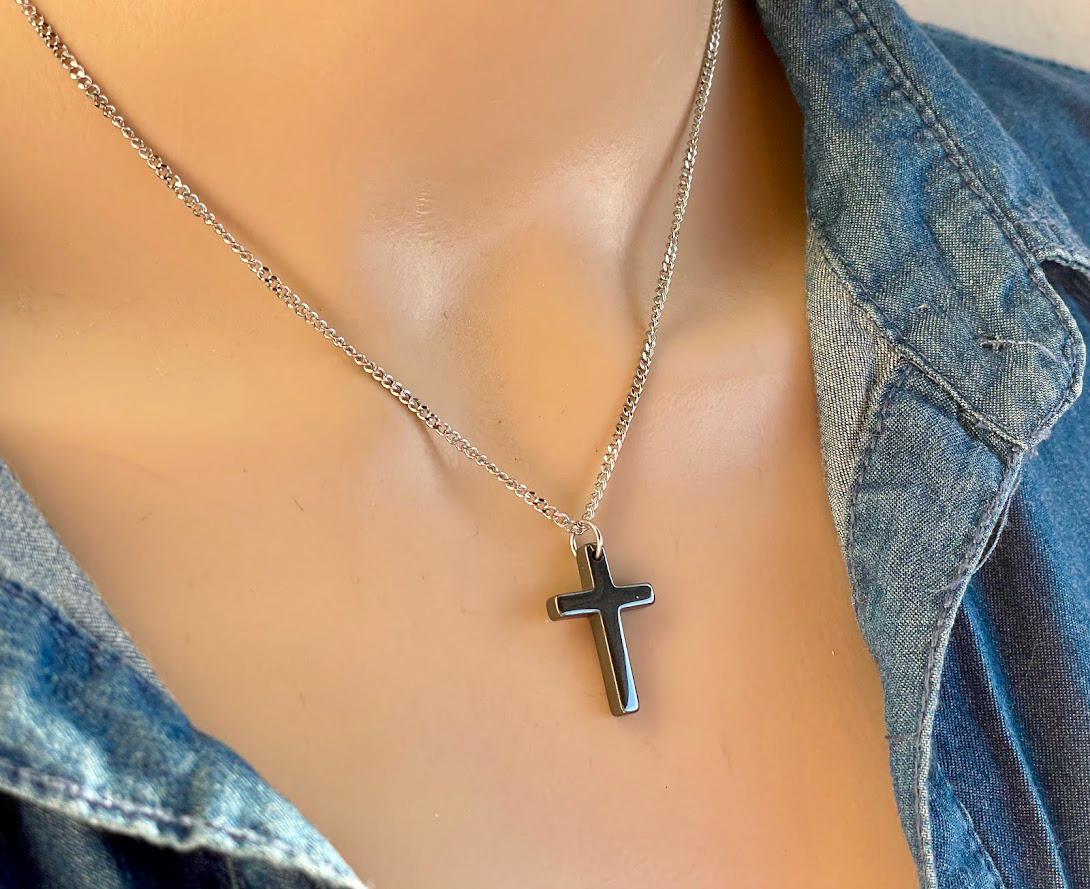 Elegant black hematite cross pendant hanging from a stainless steel chain, modern Christian necklace for everyday wear.
