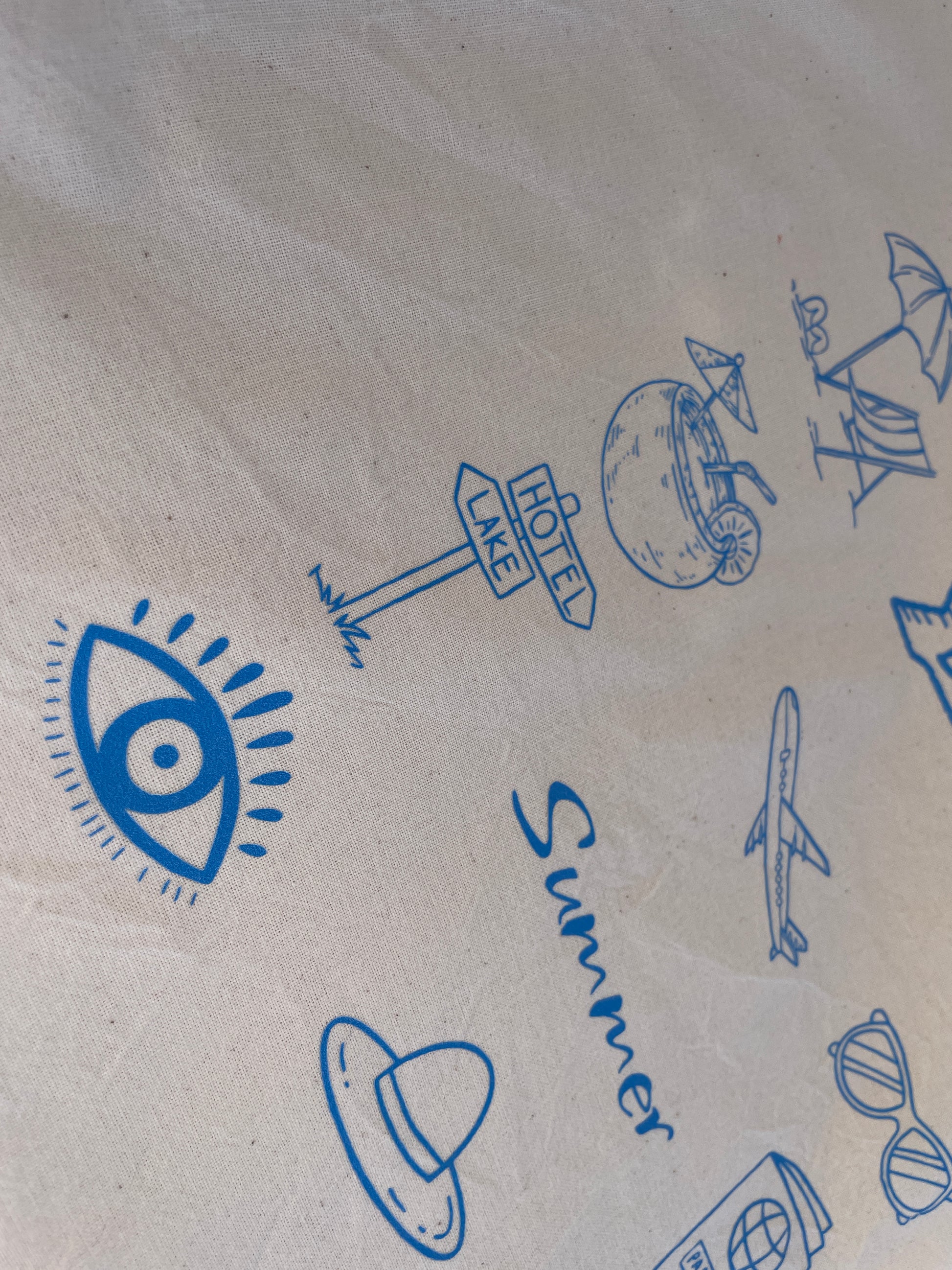 Kraft paper with blue summer-themed illustrations including an eye, airplane, and beach elements.