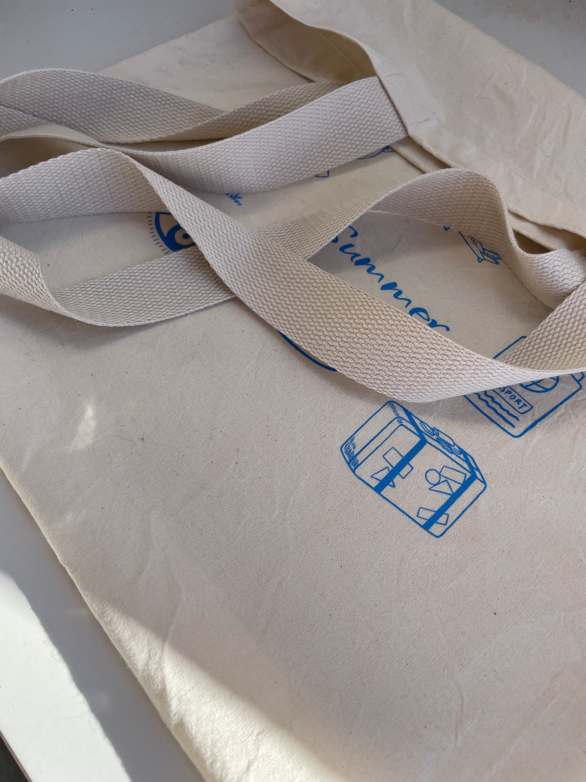 Close-up of a beige fabric with blue text and symbols on a white background