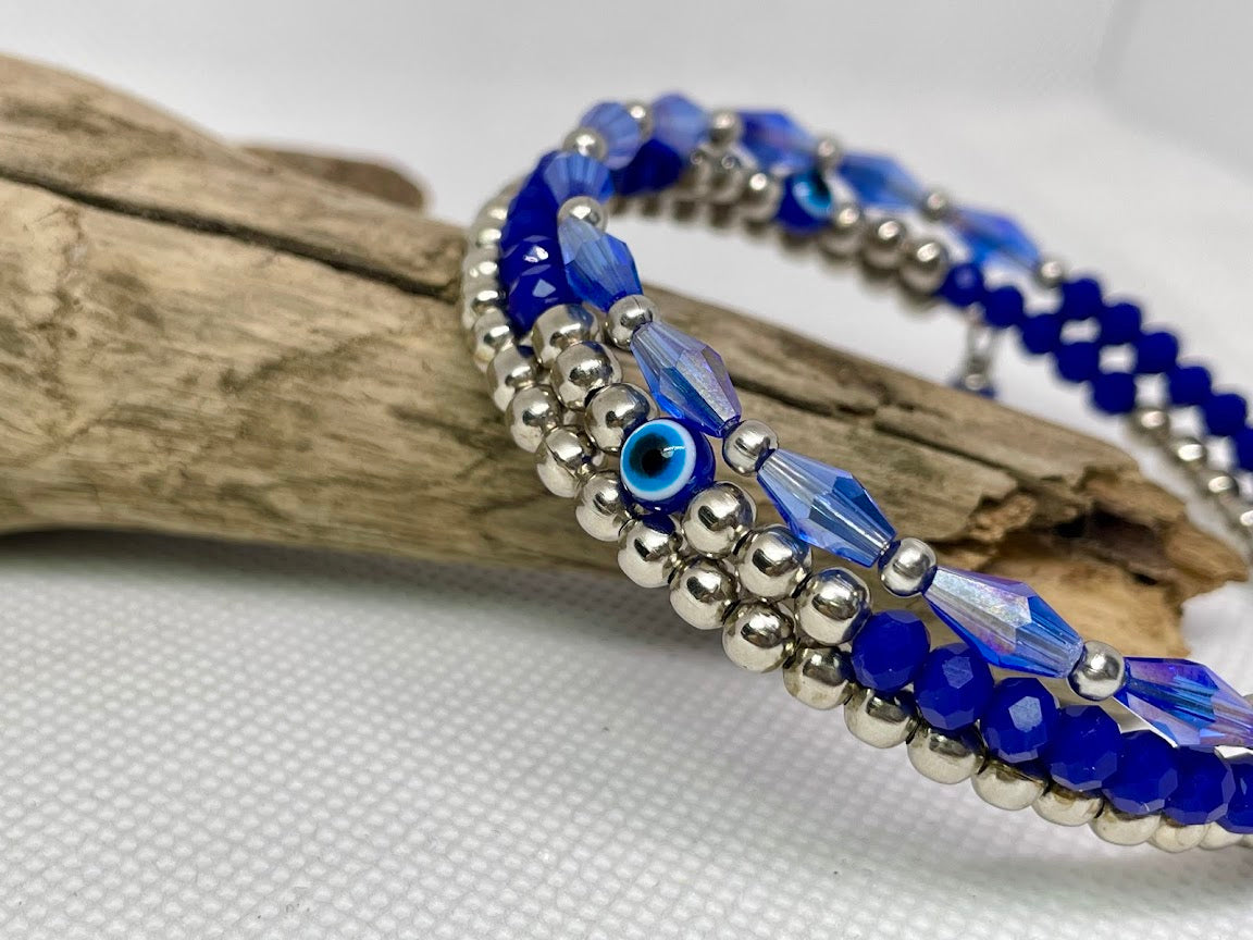 Blue beaded bracelet with silver accents on a white background