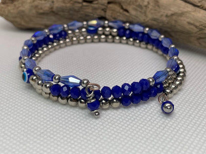 Beaded bracelet with blue and silver beads on a white surface with wooden background