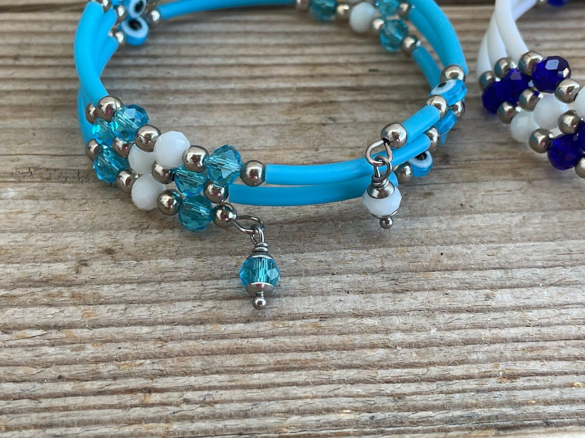 Blue bracelet with beads and a charm on a wooden surface