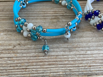 Blue bracelet with beads and a charm on a wooden surface
