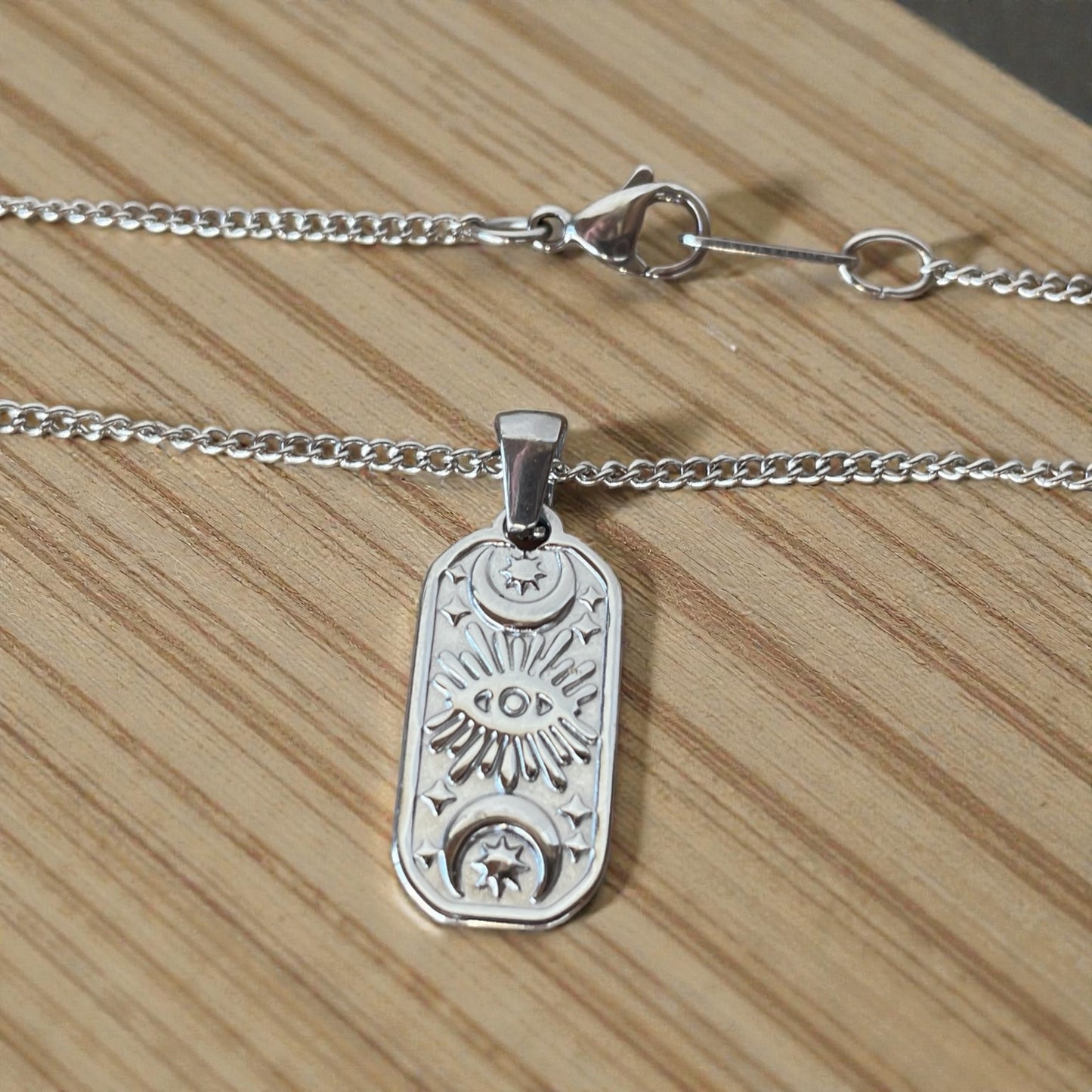 Modern stainless steel eye pendant necklace featuring a celestial-inspired design, minimalist symbolic jewelry.