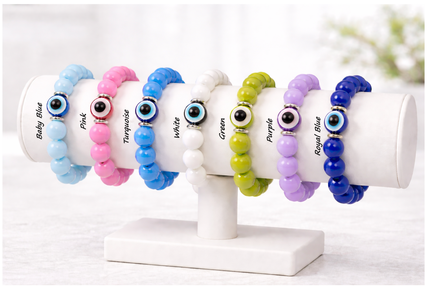 Set of colorful beaded bracelets on a white stand with labeled colors.