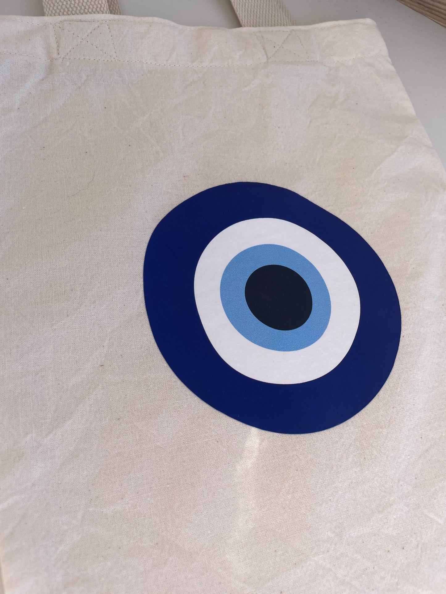 White bag with a blue, white, and black circular design on a light background