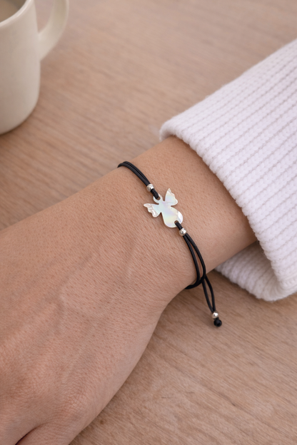 Adjustable black cord bracelet with a guardian angel charm, lightweight spiritual jewelry handmade in Greece.
