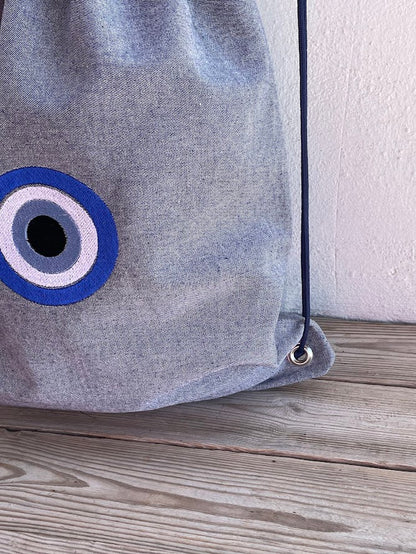 Blue-Grey Denim Drawstring Backpack with Embroidered Evil Eye