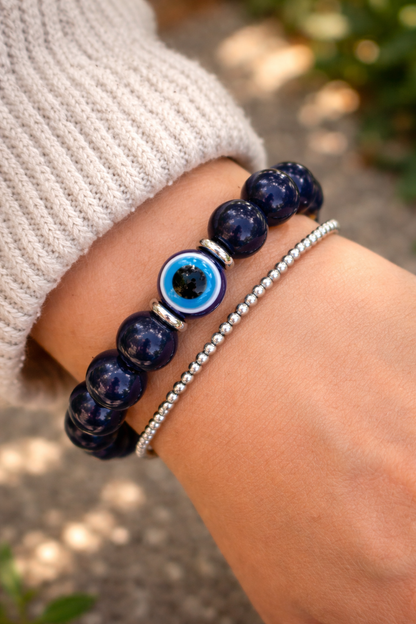 Elegant evil eye beaded bracelet on a wrist with silver bracelet