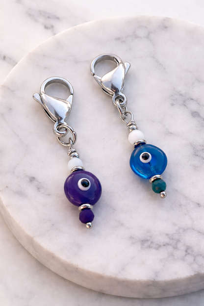 Pair of silver earrings with blue and purple beads on a marble surface