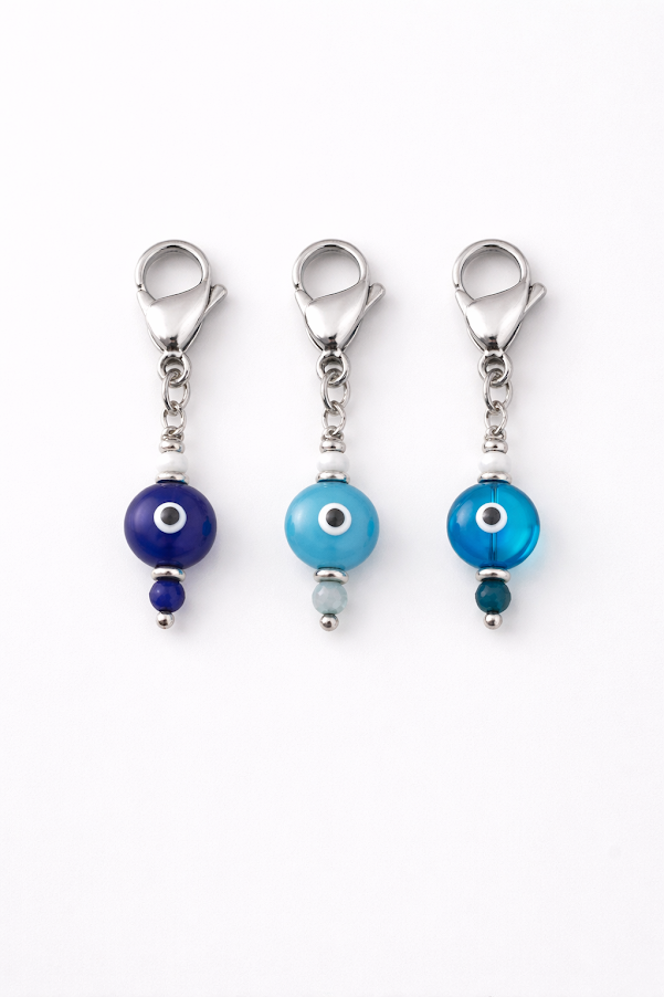Three blue evil eye charms on a white background
