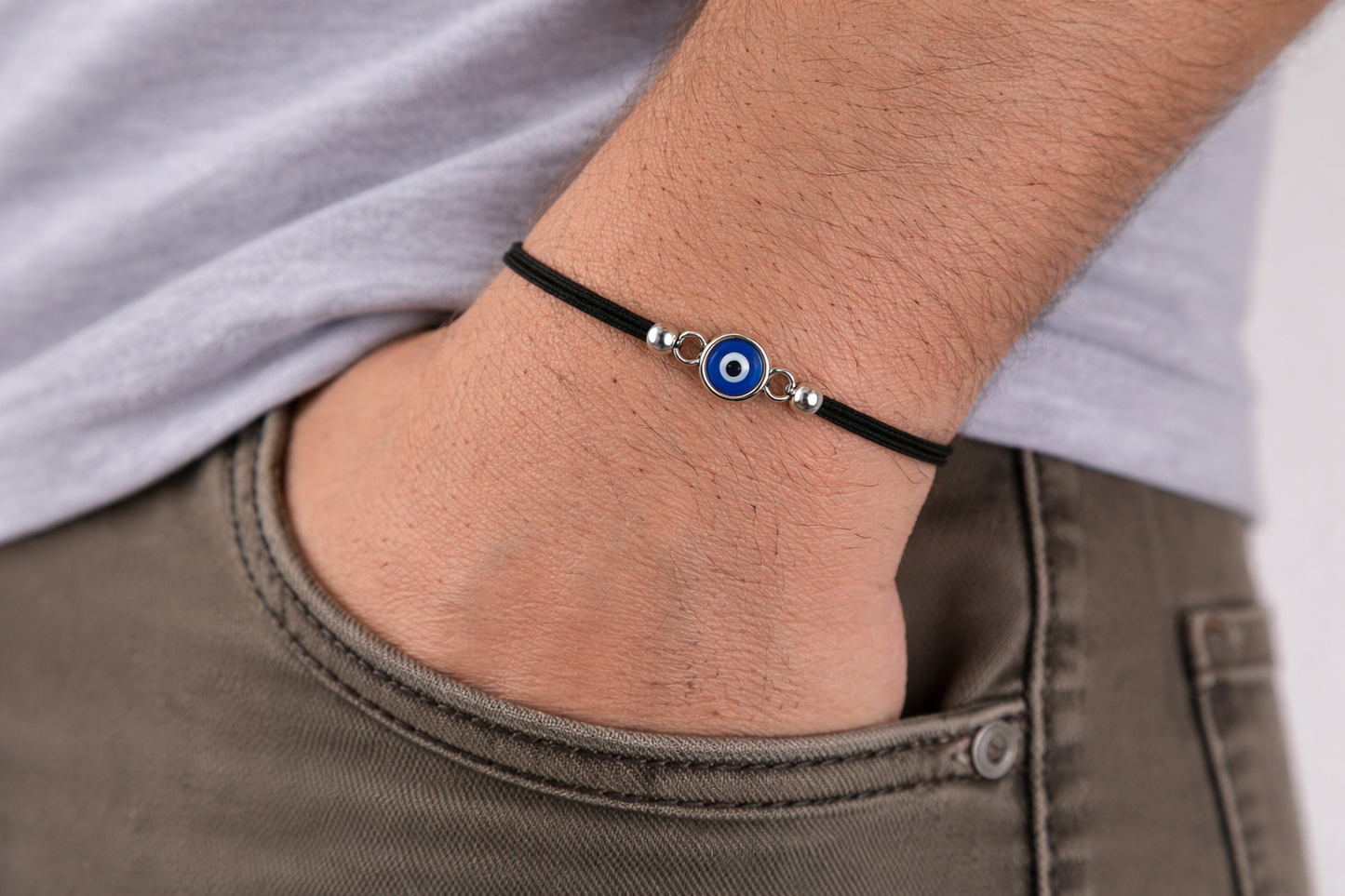 Anklet with a blue evil eye charm on a person's ankle.