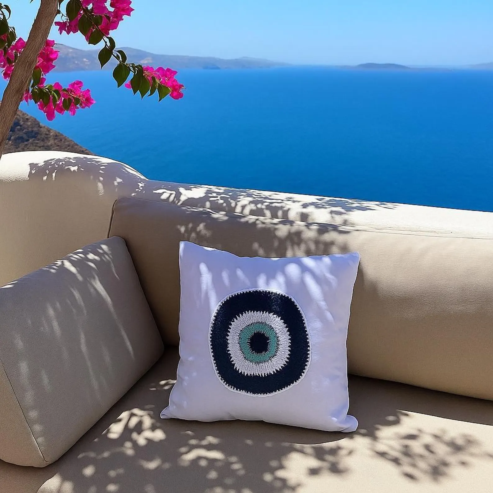 Decorative pillow with a circular pattern on a beige sofa with a scenic ocean view.