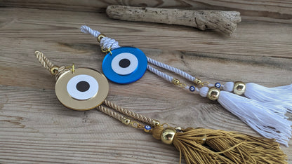 Decorative evil eye charm with tassel on a wooden surface