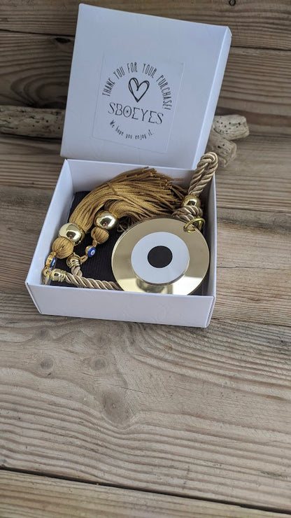 Decorative item with gold elements in a white box on a wooden surface