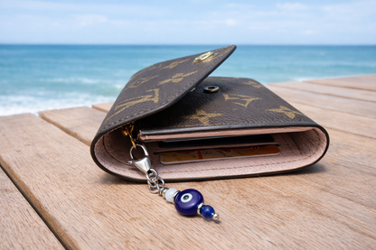 Open wallet with a keychain on a wooden surface by the ocean