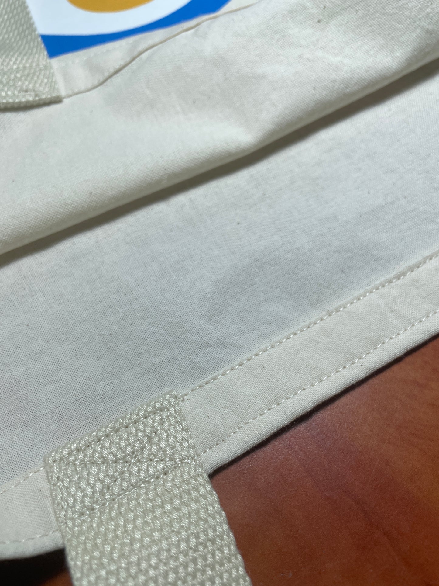 Close-up of a beige fabric with a textured pattern on a wooden surface