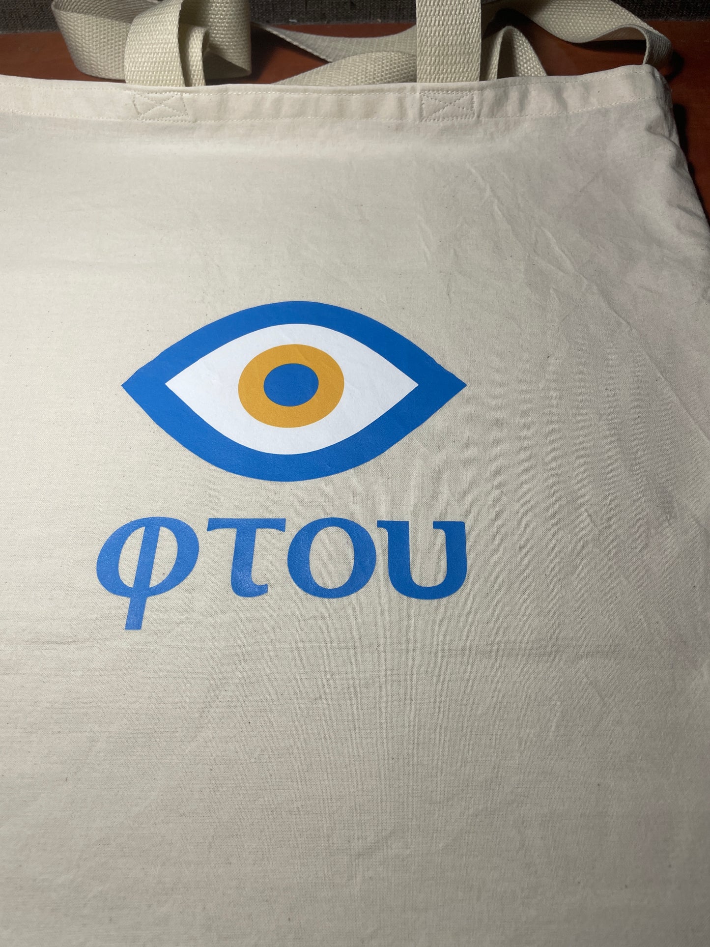 Beige tote bag with a blue and white logo and 'FOTOU' text.