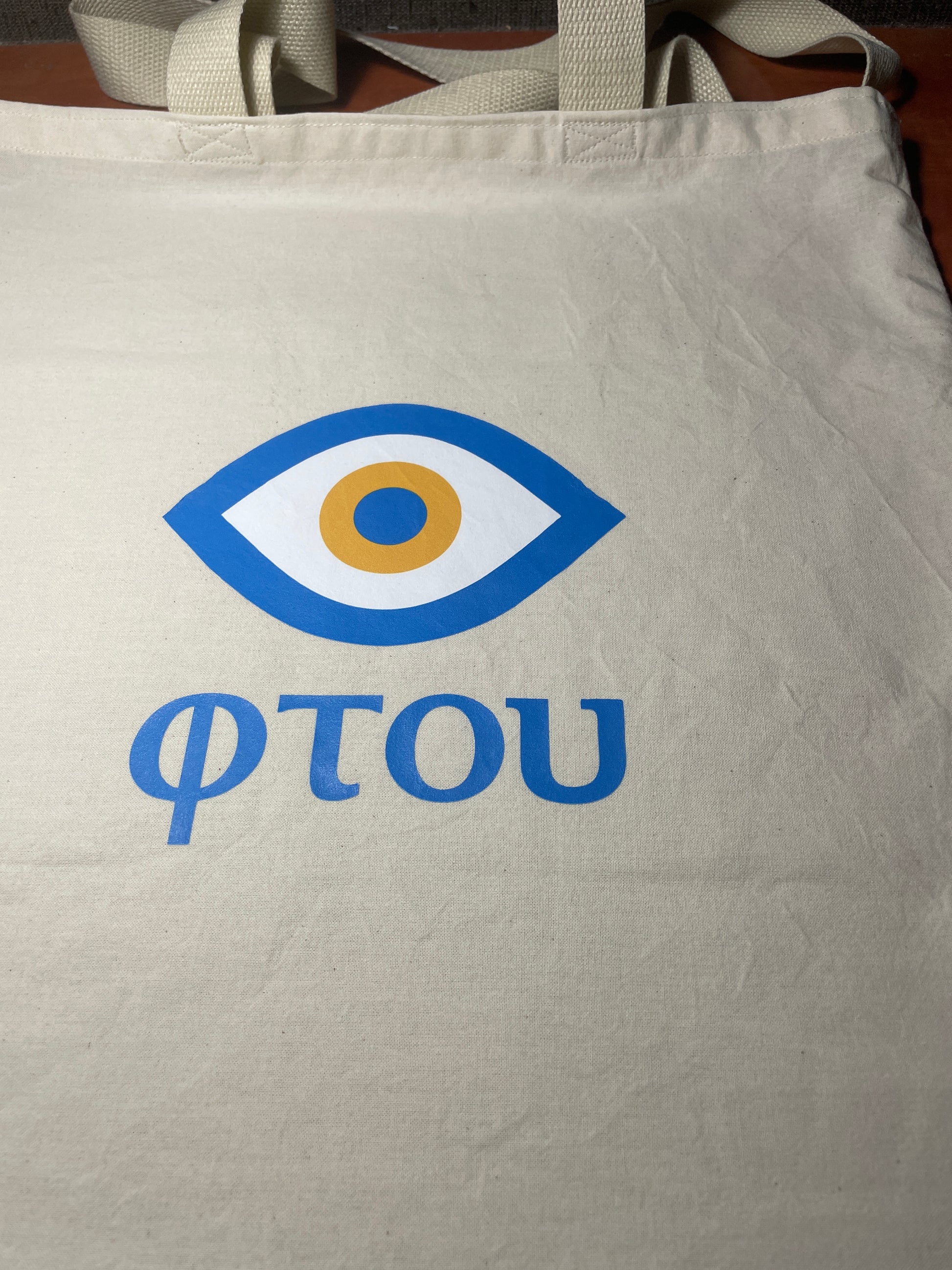Beige tote bag with a blue and white logo and 'FOTOU' text.