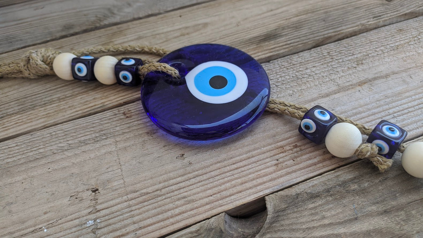Close-up of handmade blue glass evil eye with natural rope.