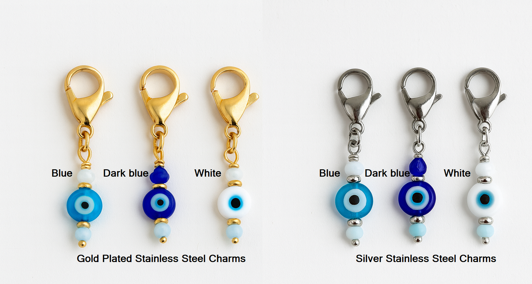 Set of evil eye charms in gold, dark blue, and white on a white background.
