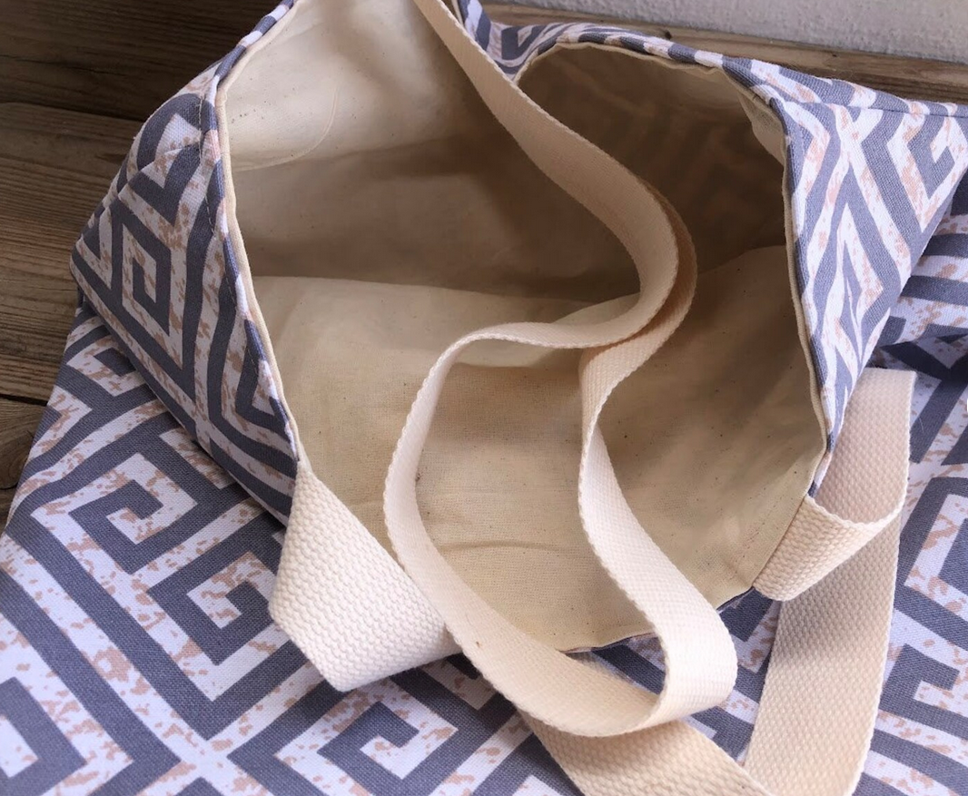 Beige tote bag on a patterned fabric surface
