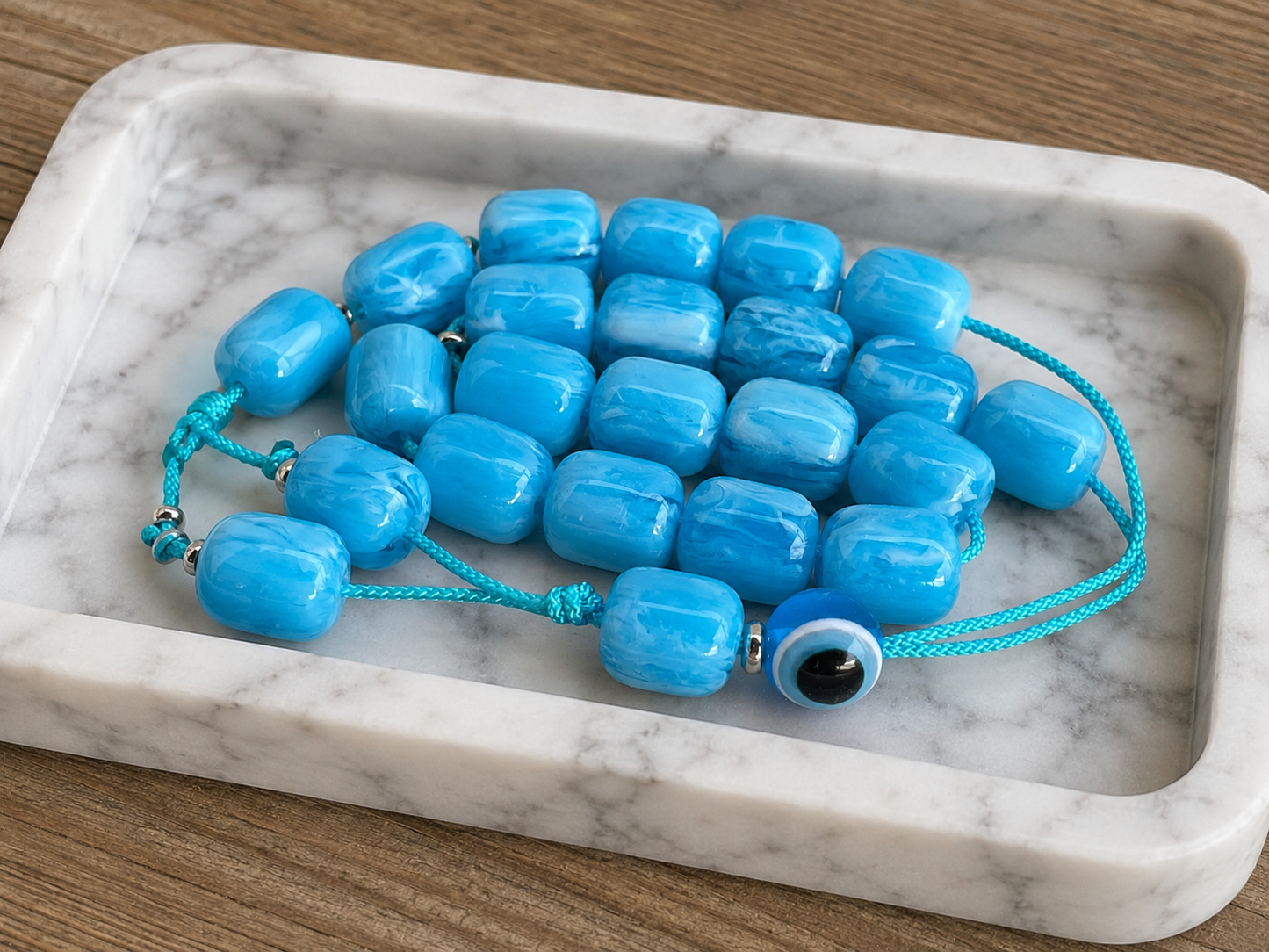 Traditional Greek worry beads made with marbled turquoise acrylic beads, a blue evil eye bead, and decorative cord tassels.