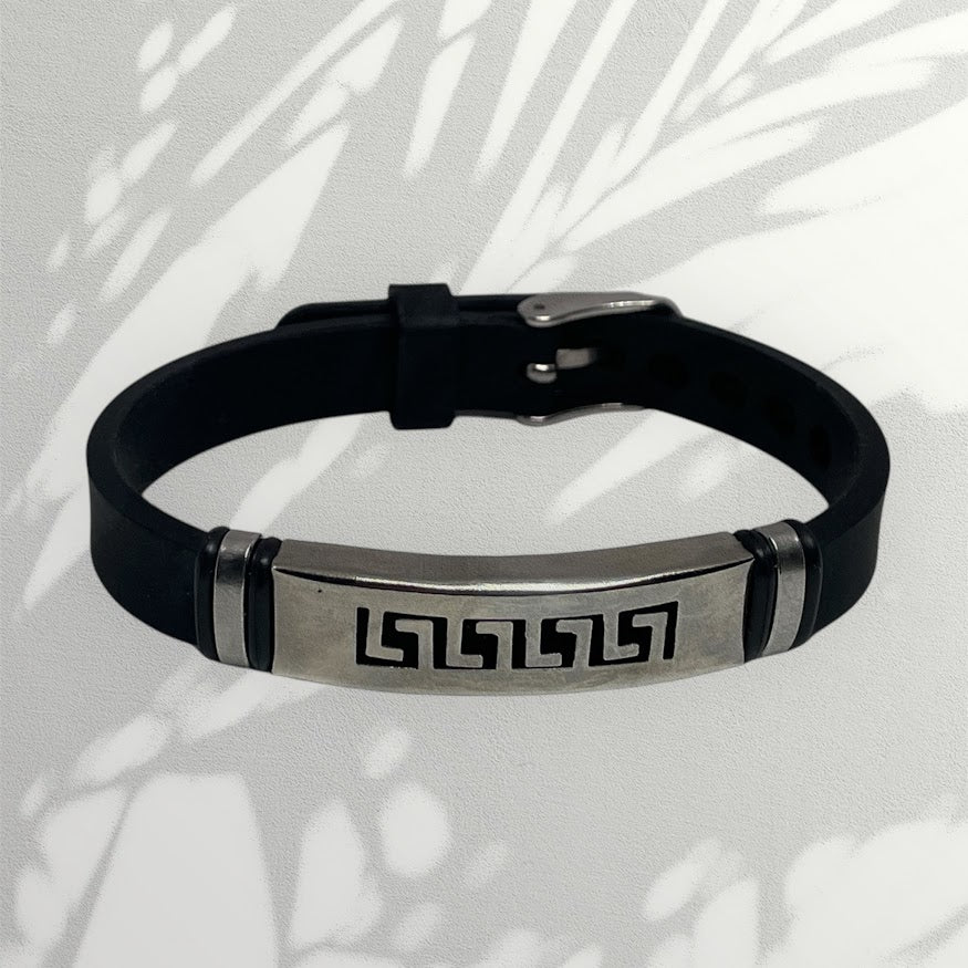 Black leather bracelet with metallic tag on a light background