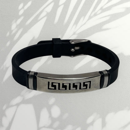 Black leather bracelet with metallic tag on a light background