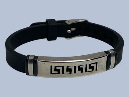 Black leather bracelet with metallic clasp and engraved design on a light blue background