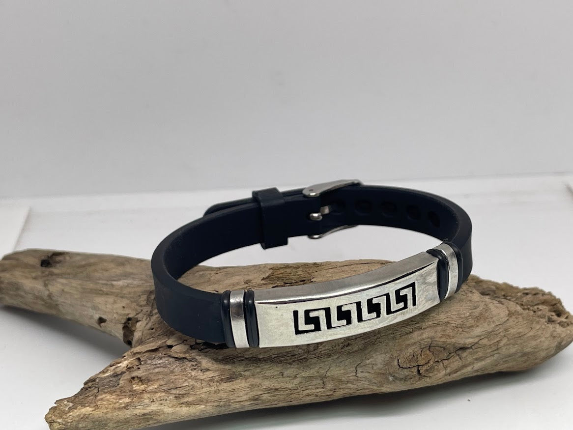 Black silicone bracelet with metal tag on a wooden surface