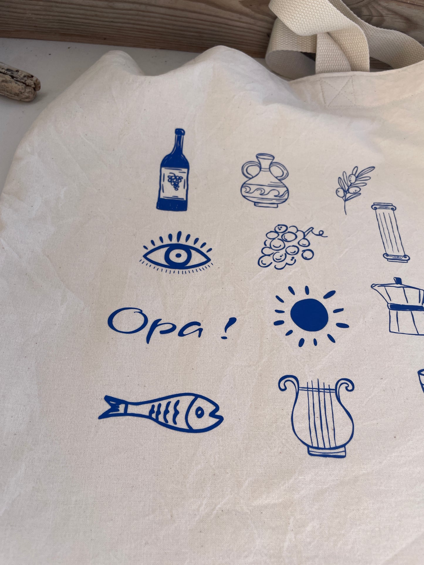 White tote bag with blue Mediterranean-themed illustrations and text.