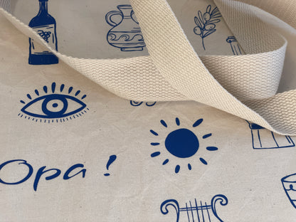 Close-up of fabric with blue printed designs including an eye, sun, and text on a white background.