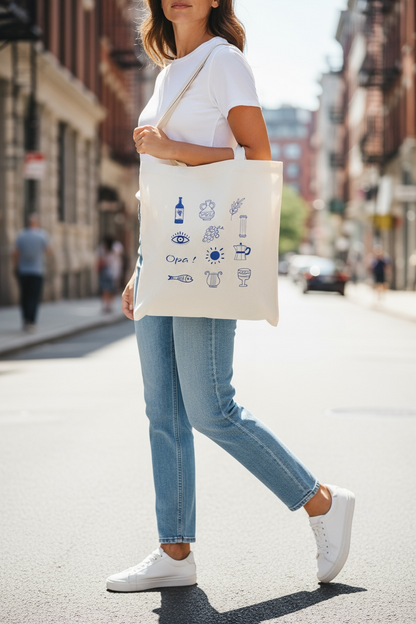 Person walking on a city street holding a tote bag with illustrations.
