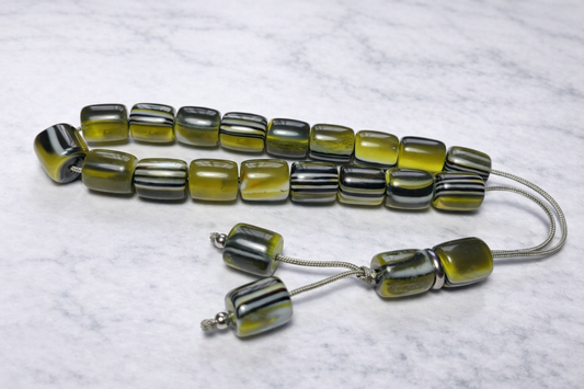 worry beads with striped beads on a textured white background
