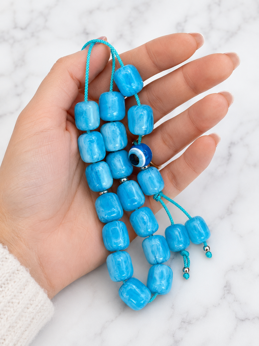 Traditional Greek komboloi with marbled turquoise acrylic beads, evil eye accent, and braided turquoise cord.