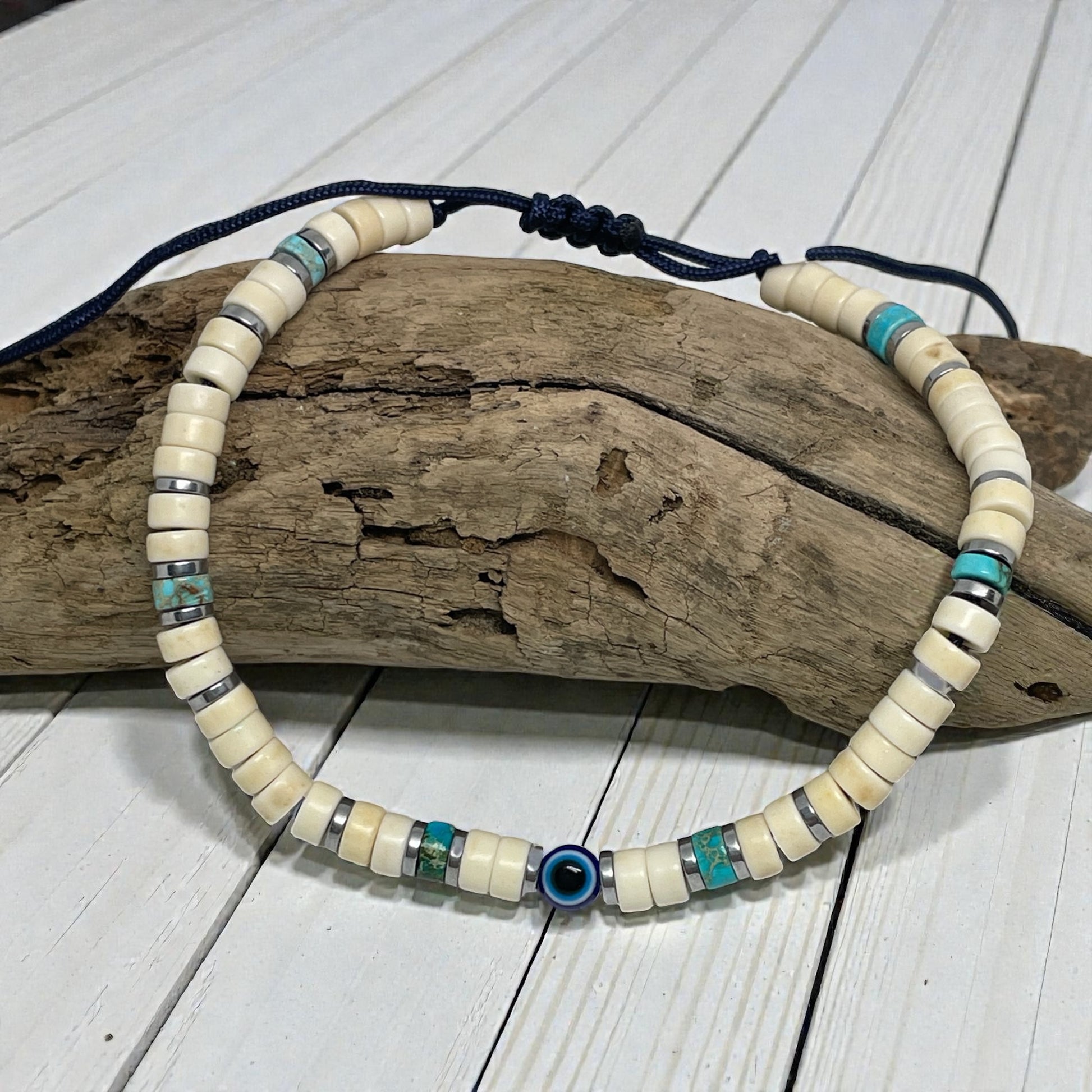 Beaded necklace with blue and turquoise accents on a wooden log