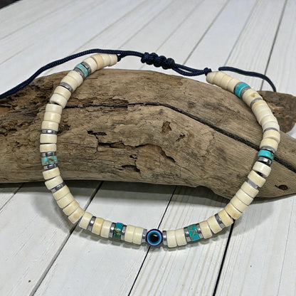 Beaded necklace with blue and turquoise accents on a wooden log