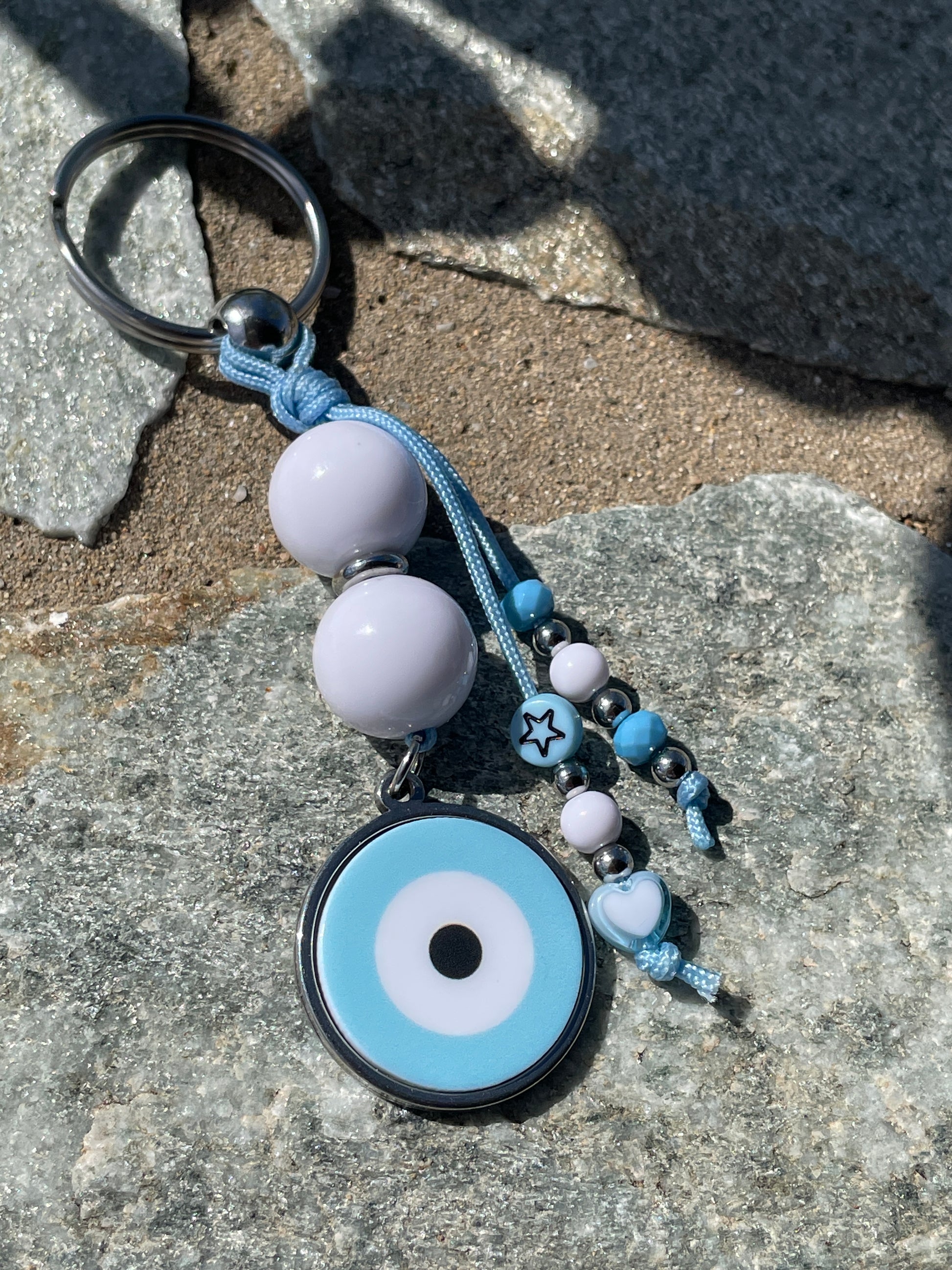 Keychain with beads and an eye design on a stone surface