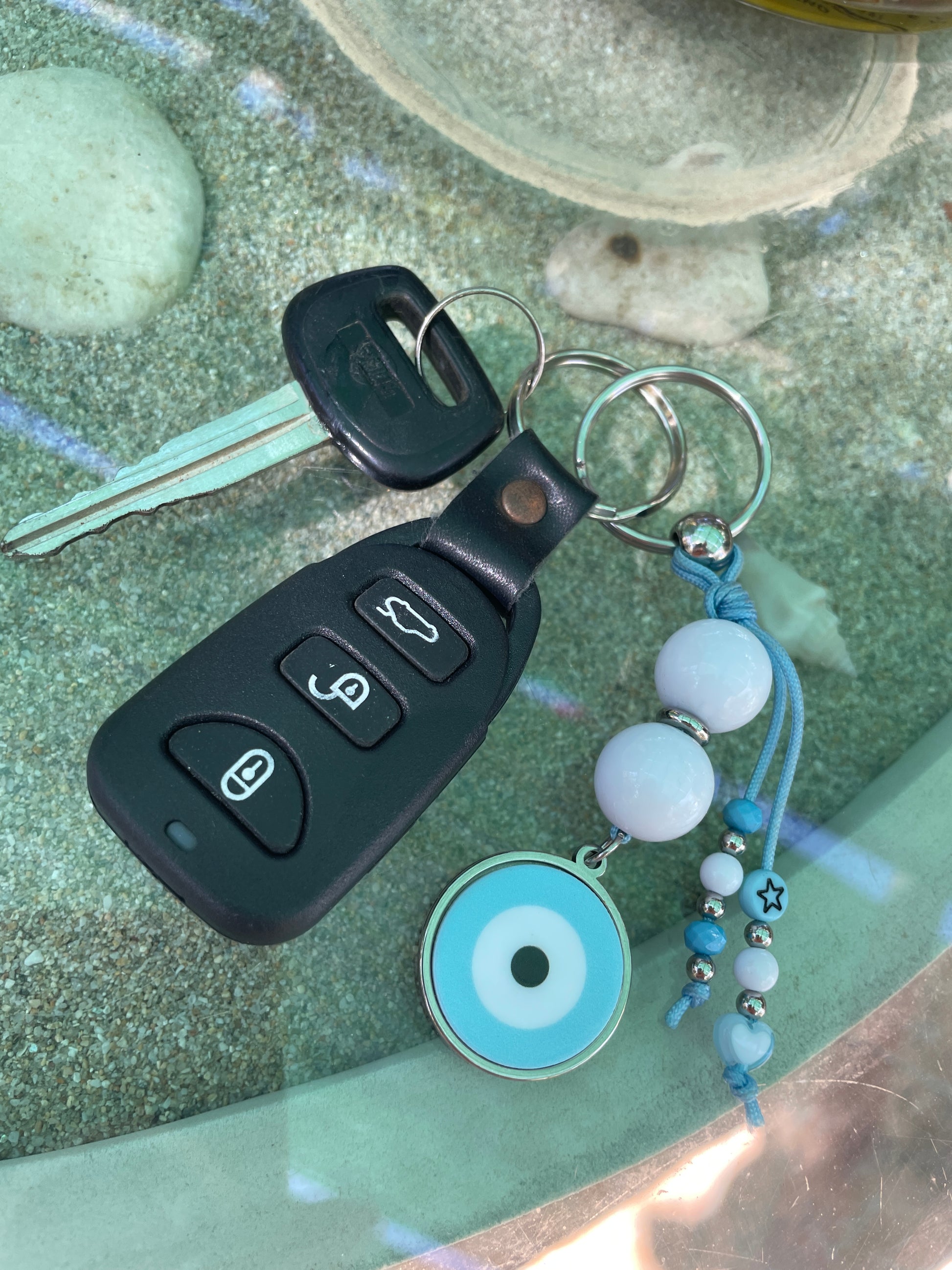 Keychain with car key fob and decorative elements on a textured surface