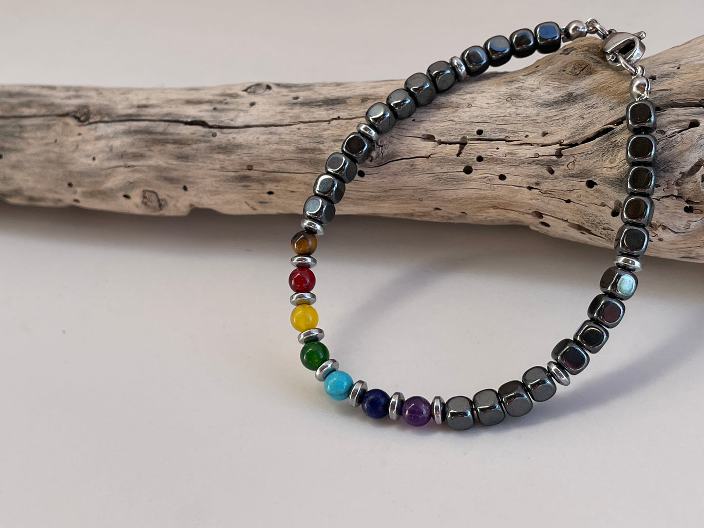 Bracelet with black beads and colorful beads on a wooden branch