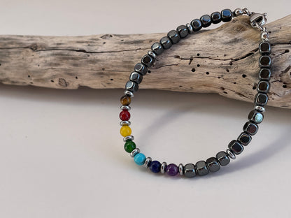 Bracelet with black beads and colorful beads on a wooden branch