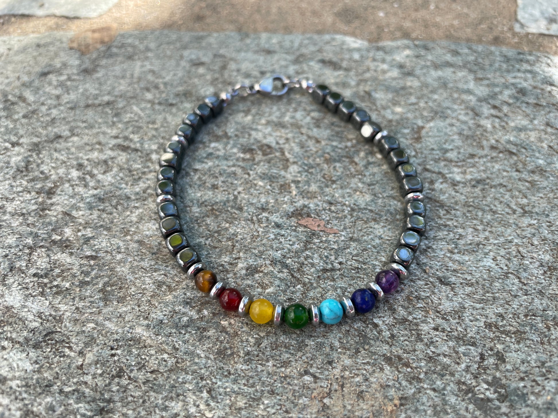 Beaded bracelet with multicolored beads on a stone surface