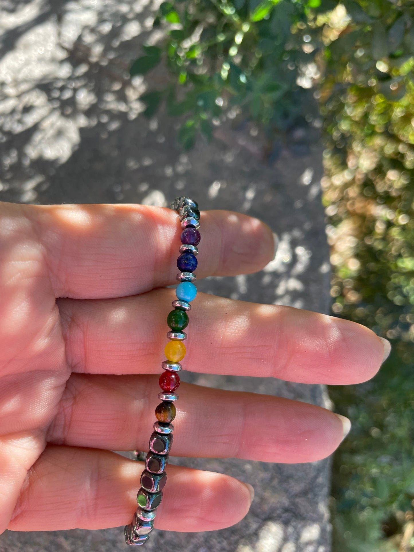 Multicolored beaded bracelet on a hand with a blurred natural background