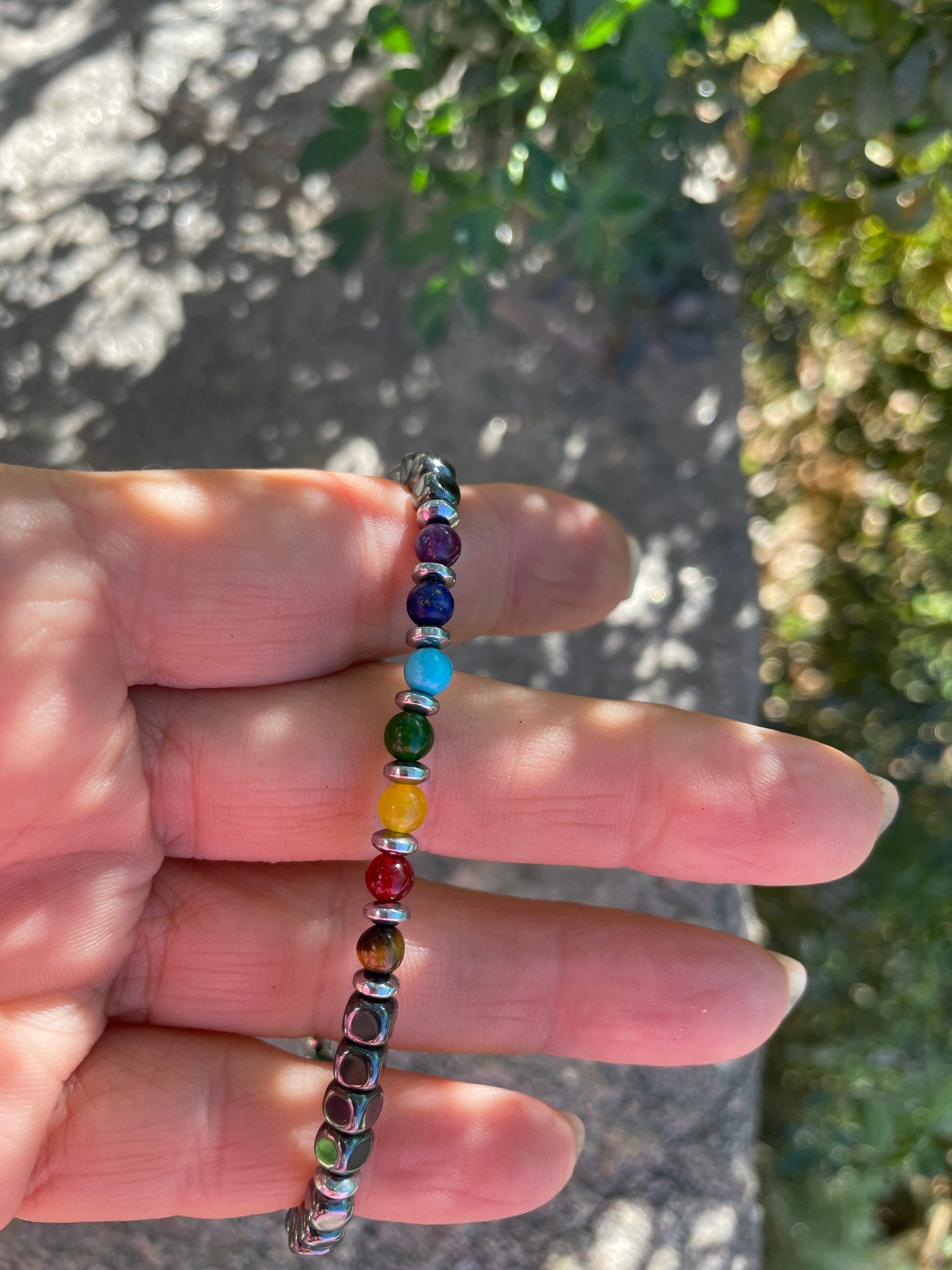 Multicolored beaded bracelet on a hand with a blurred natural background