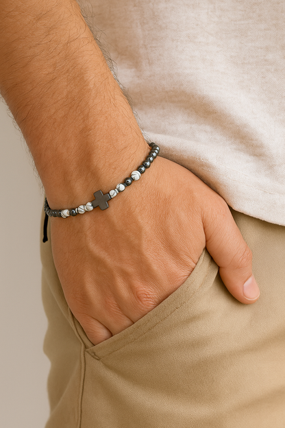 Hand wearing a bracelet with a star charm, with beige pants and a neutral background