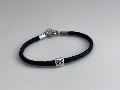 Black braided bracelet with a silver clasp on a light gray background