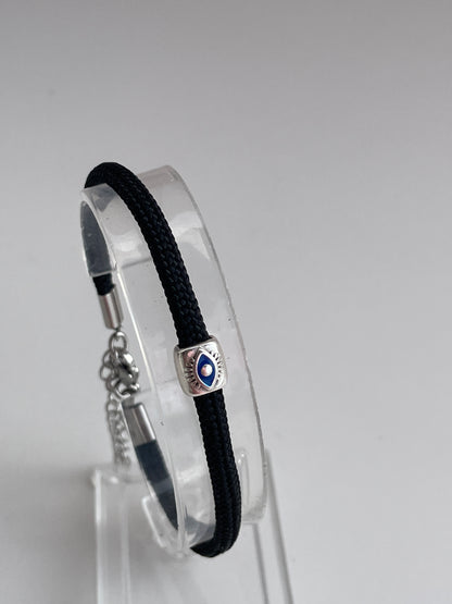 Black bracelet with a silver clasp on a clear stand against a gray background