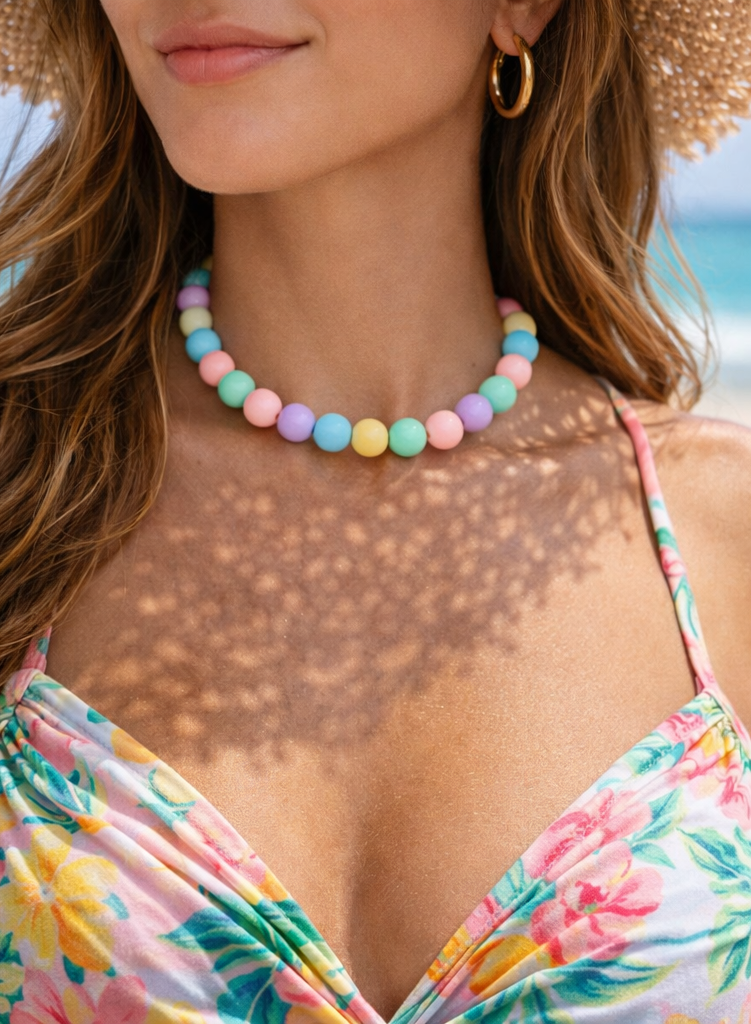 Woman wearing a colorful beaded necklace with a floral dress against a beach background